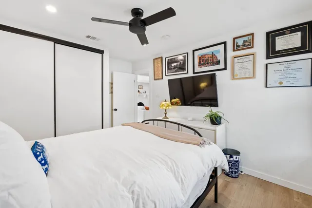 a bedroom with a bed and wooden floor