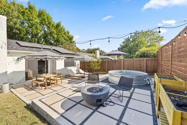 a view of a patio with couches table and chairs and potted plants