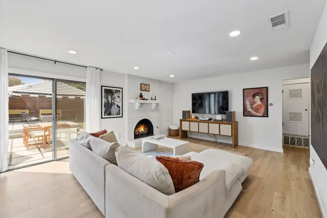a living room with furniture a flat screen tv and a large window