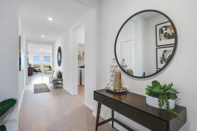 a living room with furniture a mirror and a potted plant