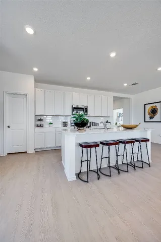 a kitchen with kitchen island white cabinets and stainless steel appliances