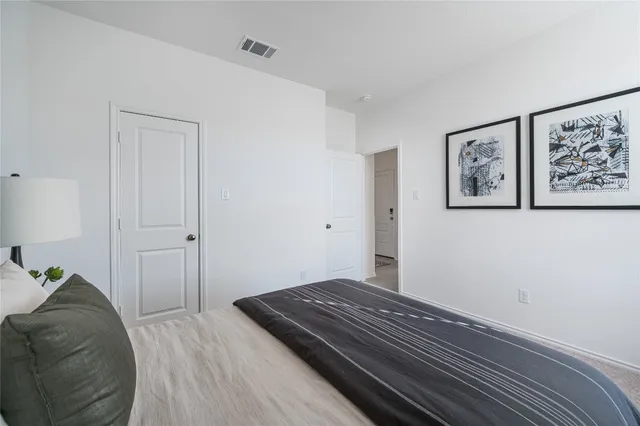 a bedroom with a bed and painting on the wall