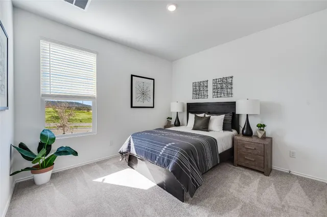 a living room with a bed furniture and a potted plant