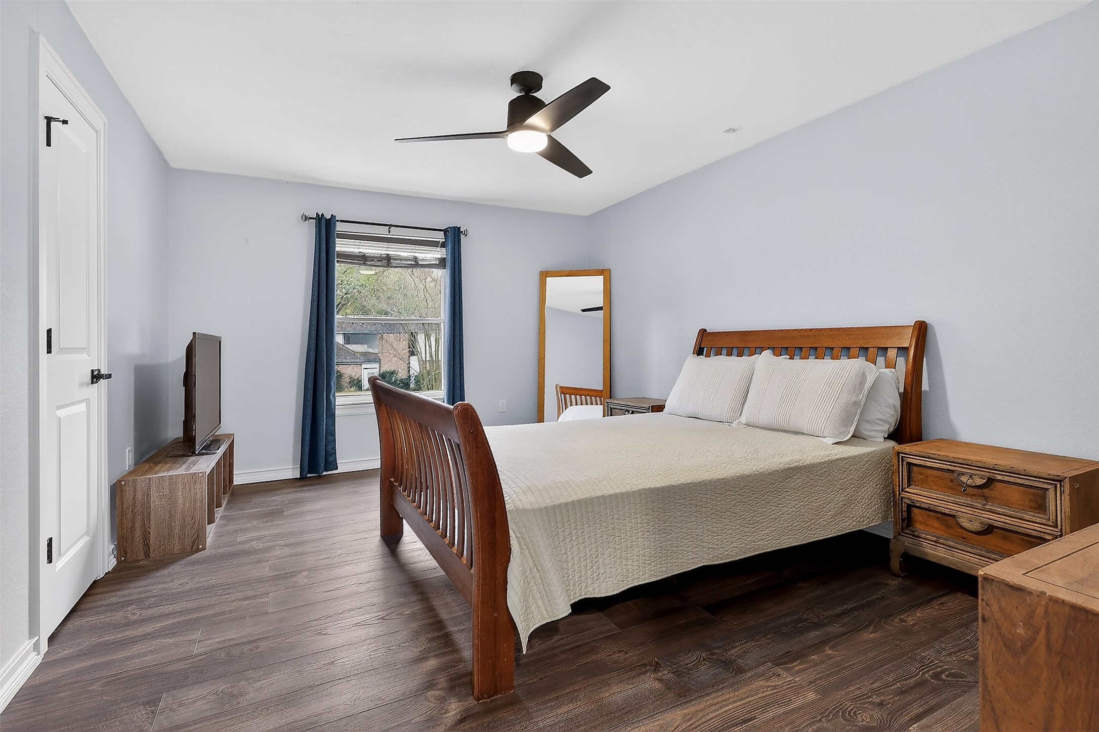 17106 Spring Creek Forest Drive Spring, TX 77379 - Photo 23 of 49 This bright and inviting bedroom features durable wood-look flooring and a cool-toned neutral palette. The space is anchored by a large window that floods the room with natural light, while a contemporary matte black ceiling fan and recessed lighting ensure a perfectly lit ambiance. Like the rest of the home, the attention to detail is evident with updated matte black door hardware and clean, modern trim.