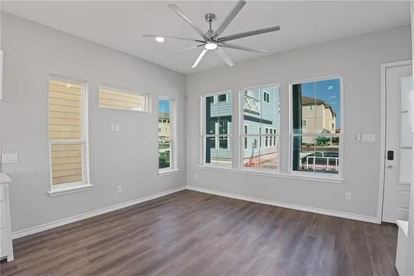 a view of an empty room with a window and wooden floor