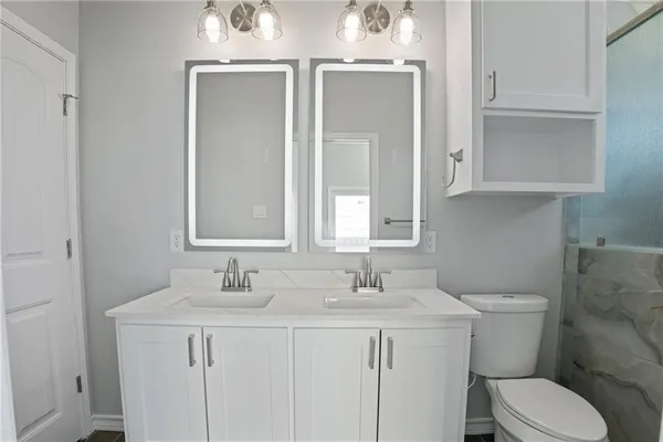 a bathroom with a toilet sink and mirror