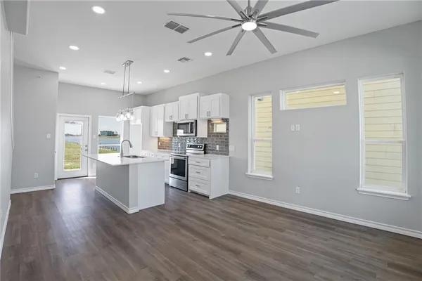 a view of kitchen with sink microwave and refrigerator