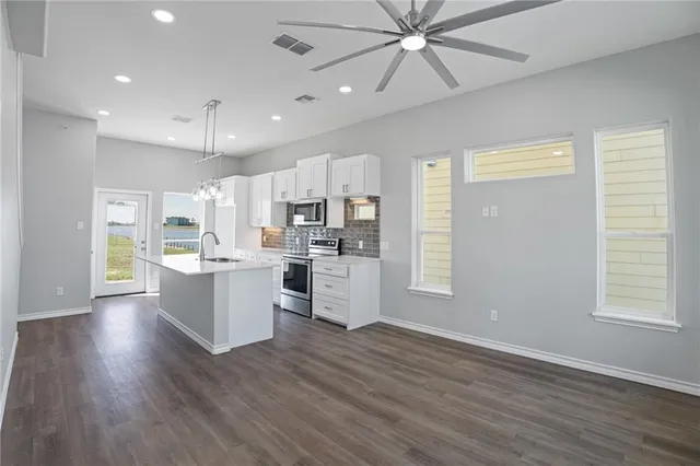 a view of kitchen with sink microwave and refrigerator