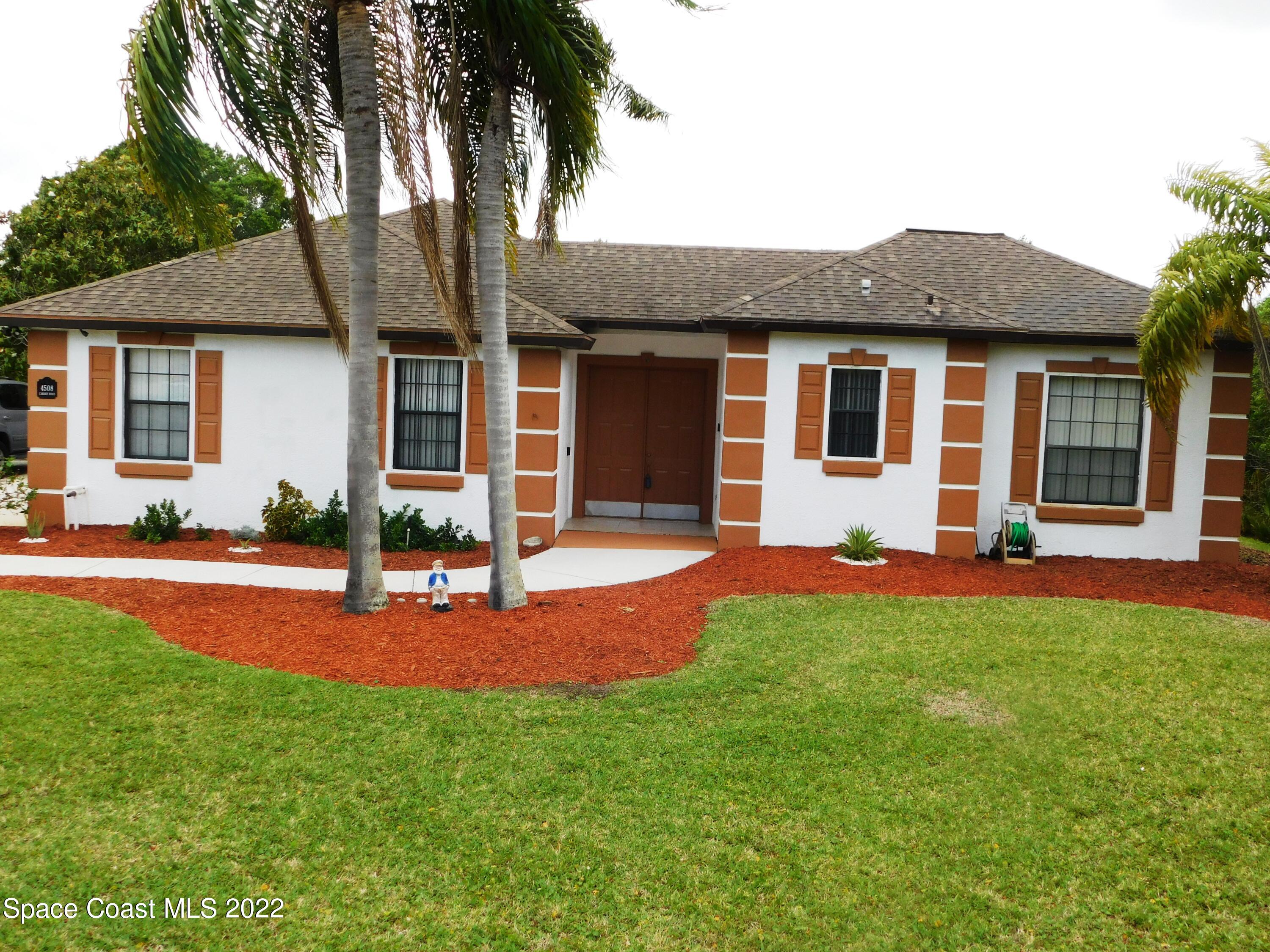 4508 Canard Road Melbourne, FL 32934 - Photo 2 of 34 a front view of house with yard and outdoor seating
