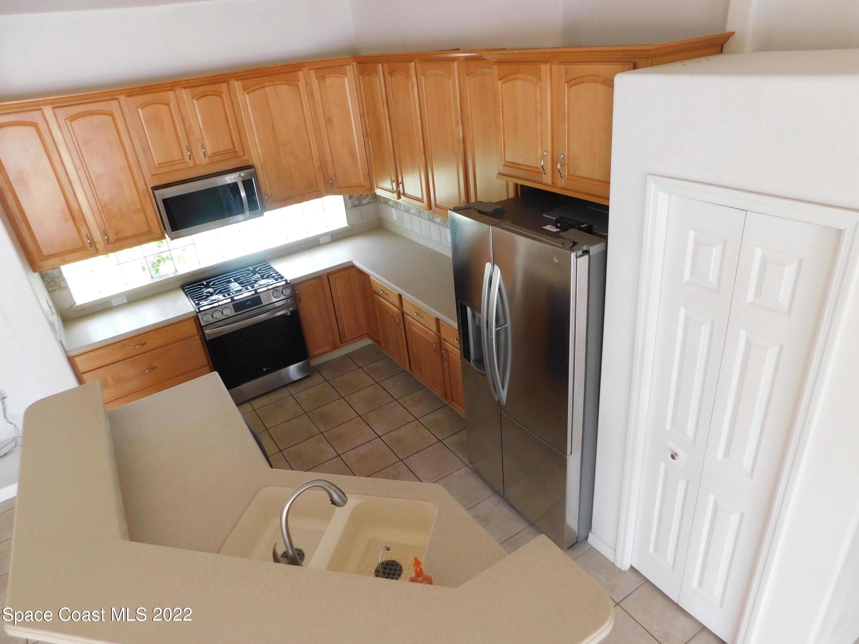 4508 Canard Road Melbourne, FL 32934 - Photo 6 of 34 a kitchen with stainless steel appliances a refrigerator and a stove top oven