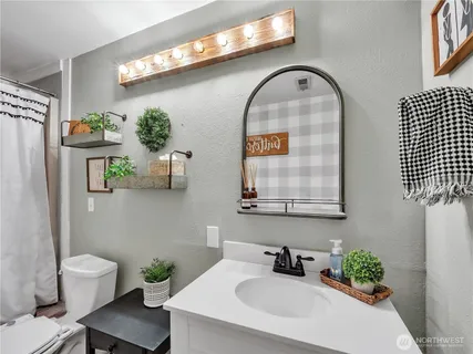 a bathroom with a sink mirror and toilet