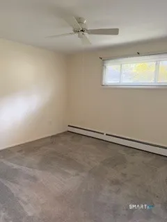 an empty room with a window and a ceiling fan