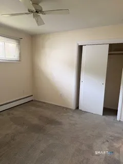 an empty room with a ceiling fan and windows