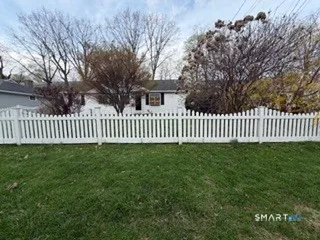 a view of a yard with wooden fence