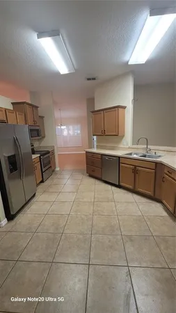 a large kitchen with a stove a sink dishwasher and a refrigerator