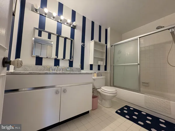a bathroom with a double vanity sink toilet and shower