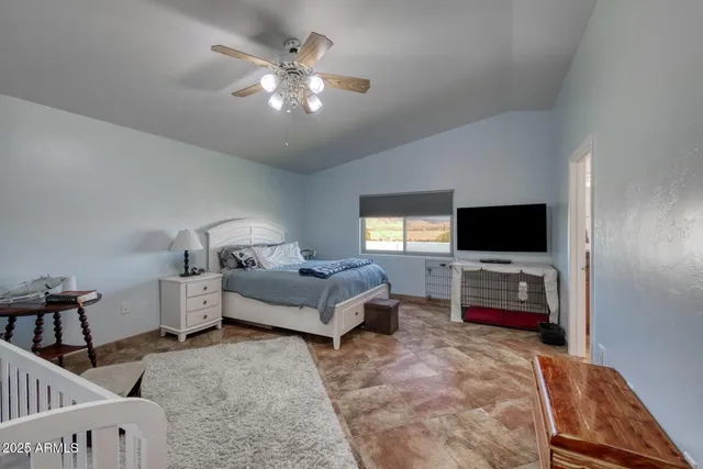 a bedroom with a bed and a flat tv screen on dresser