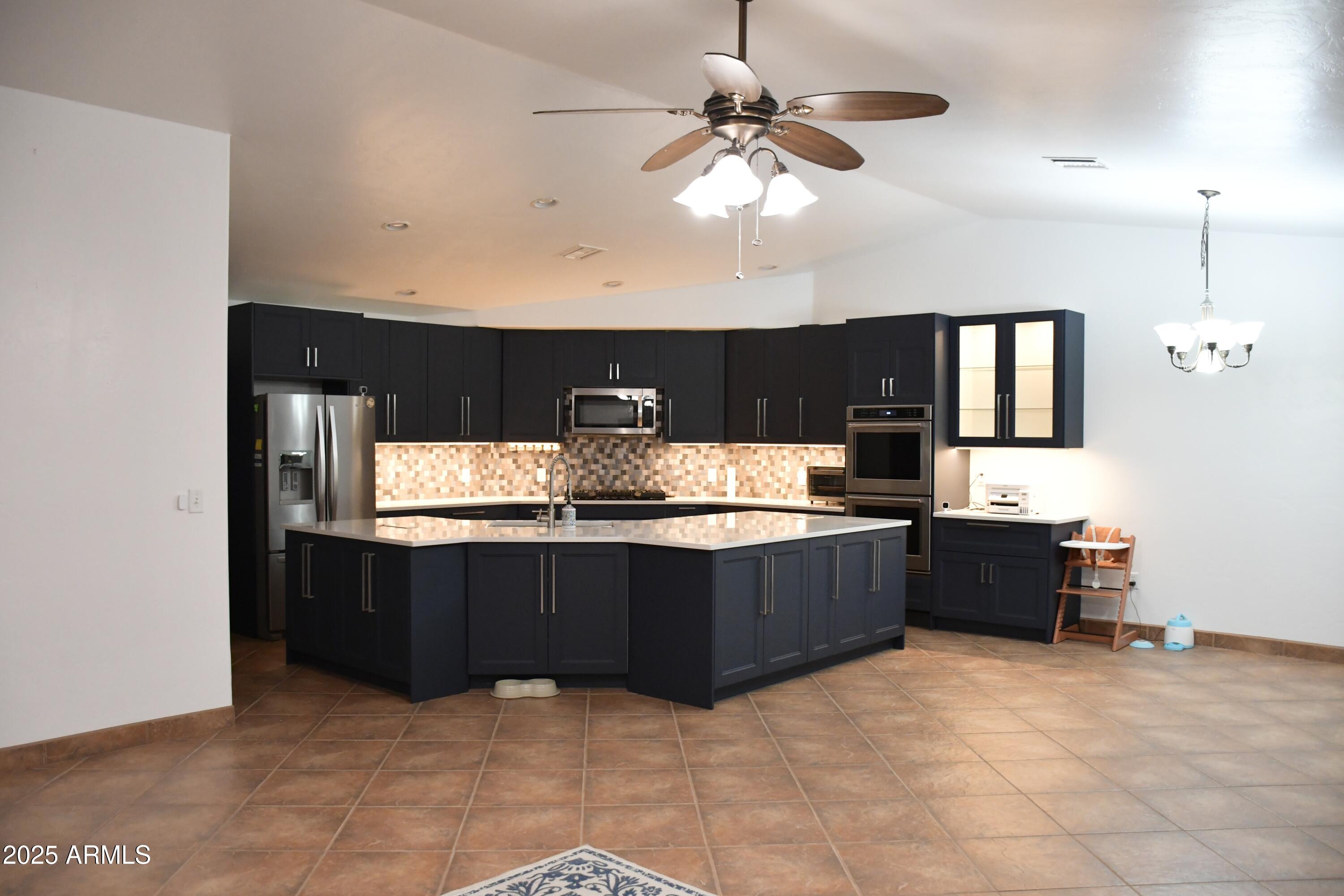3298 West Monte Vista Trail Benson, AZ 85602 - Photo 10 of 44 a kitchen with stainless steel appliances granite countertop a stove and a refrigerator