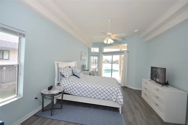 a bedroom with a bed and a flat tv screen on dresser