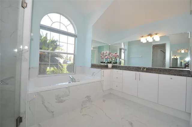 a bedroom with a bed and a large window with balcony view