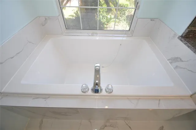 a bedroom with a bed and a flat tv screen on dresser