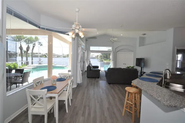 a dining room with wooden floor a chandelier a wooden table and chairs
