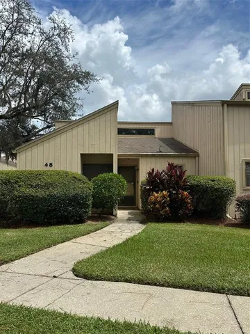 a front view of a house with a garden and yard