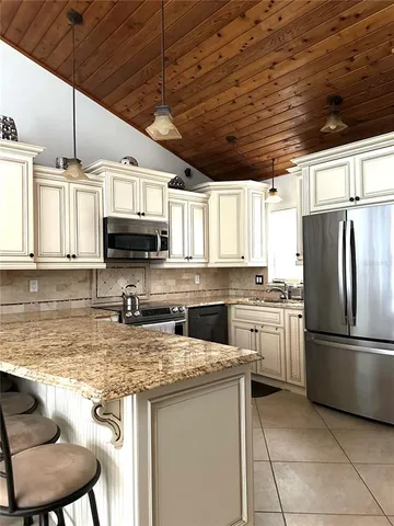 a kitchen with stainless steel appliances granite countertop a refrigerator a stove top oven a sink and dishwasher