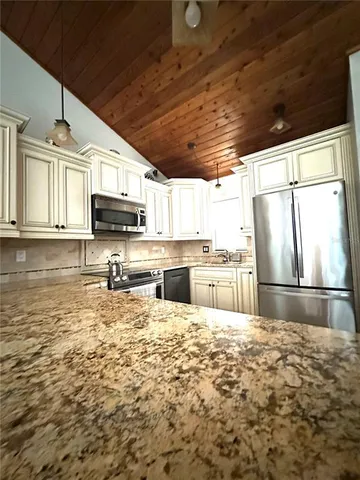 a kitchen with stainless steel appliances granite countertop a stove sink and cabinets