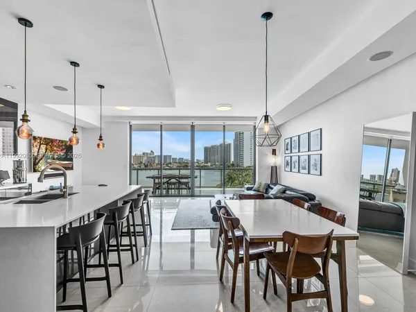 a dining room filled chandelier and wooden floor
