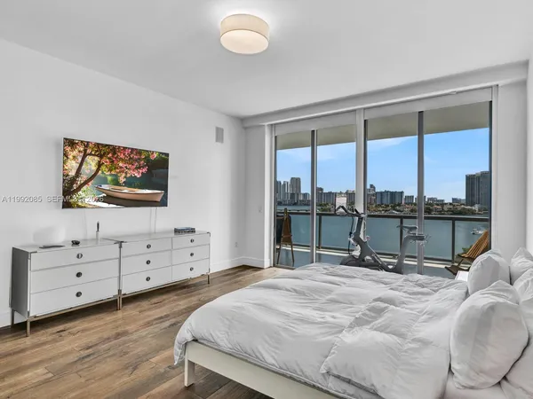 a bed room with a bed and a flat tv screen on dresser