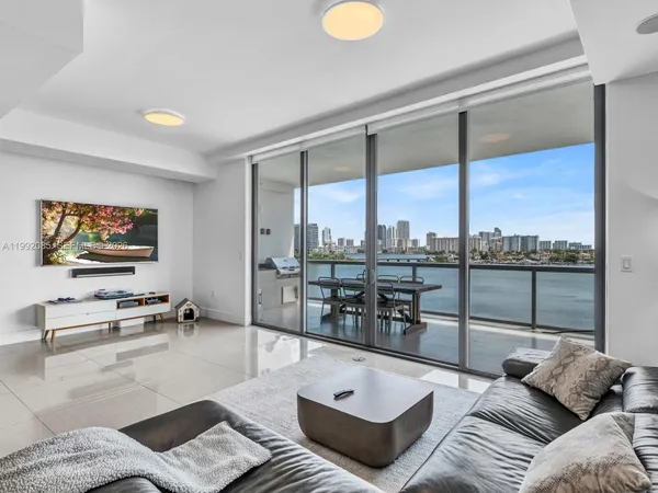 a living room with furniture a rug and a floor to ceiling window