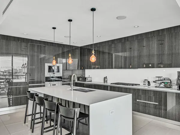 a kitchen with a sink a counter space appliances and cabinets