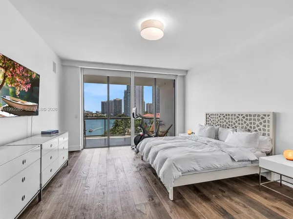 a bedroom with a bed and a flat tv screen on the dresser