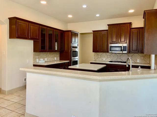 a kitchen with kitchen island granite countertop a stove and a sink