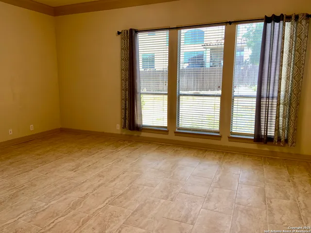 a view of an empty room with closet and a window