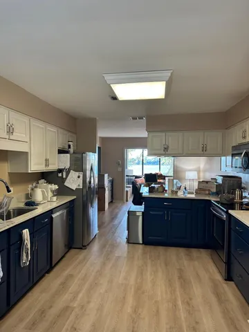 a kitchen with stainless steel appliances granite countertop a sink a stove and cabinets
