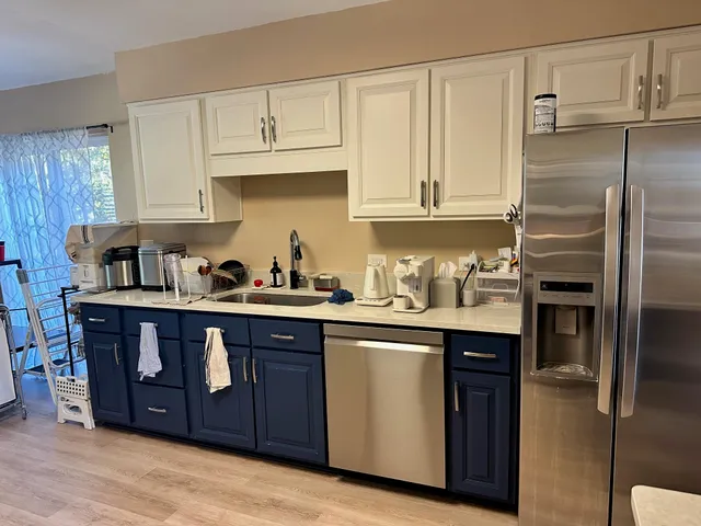 a kitchen with granite countertop a stove top oven a sink dishwasher and a refrigerator with wooden floor