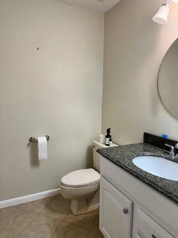 a bathroom with a granite countertop toilet and sink