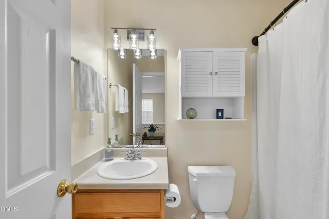 a bed sitting in a bedroom next to a window and a chandelier