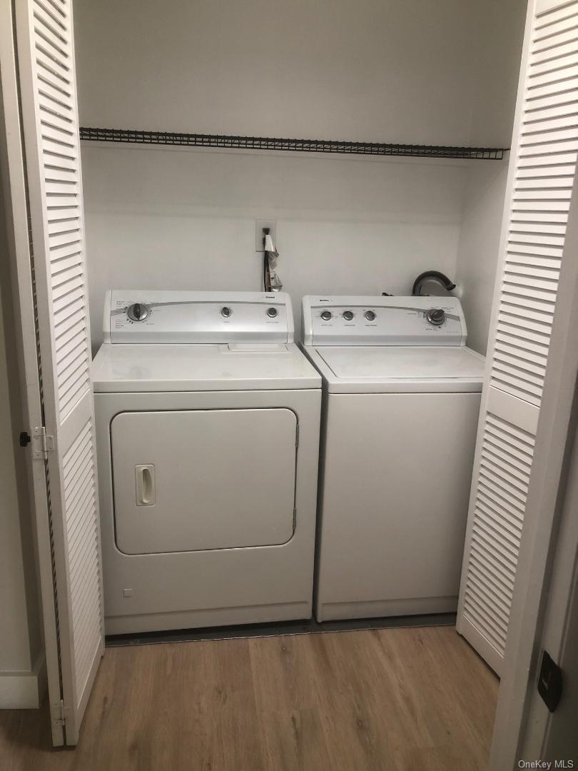 85 North Middletown Road, Unit D10 Nanuet, NY 10954 - Photo 12 of 12 Dedicated laundry closet featuring louvered bi-fold doors, a full size washer and dryer, and a wire storage shelf.