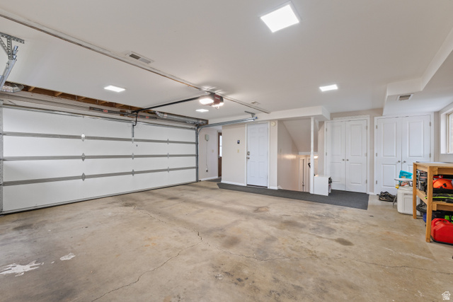 3320 Cherokee Lane Provo, UT 84604 - Photo 38 of 52 Spacious garage featuring a large sectional garage door with automatic opener, integrated ceiling lighting, an interior doorway, built-in storage closets, and a concrete floor