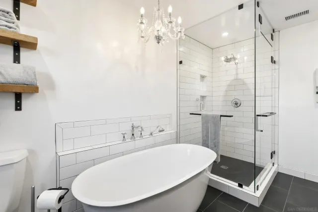 a bathroom with a granite countertop sink a mirror and a shower