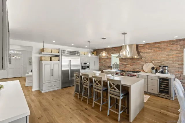 a kitchen with stainless steel appliances a white table chairs and a refrigerator