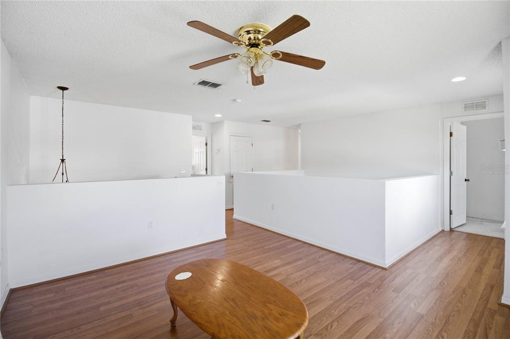 206 Taranto Way Kissimmee, FL 34758 - Photo 21 of 45 a view of an empty room with window and wooden floor