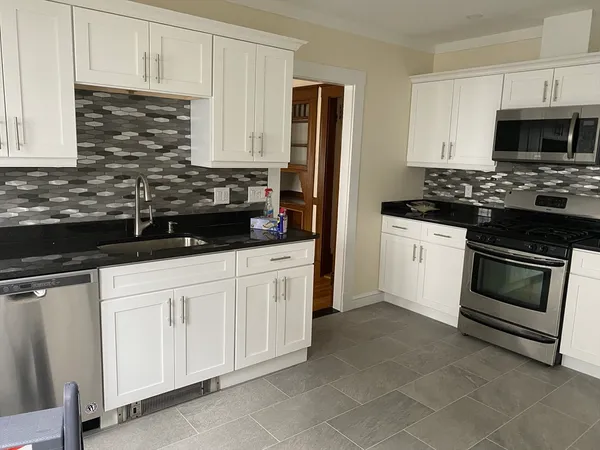 a kitchen with stainless steel appliances granite countertop a stove a sink and a microwave