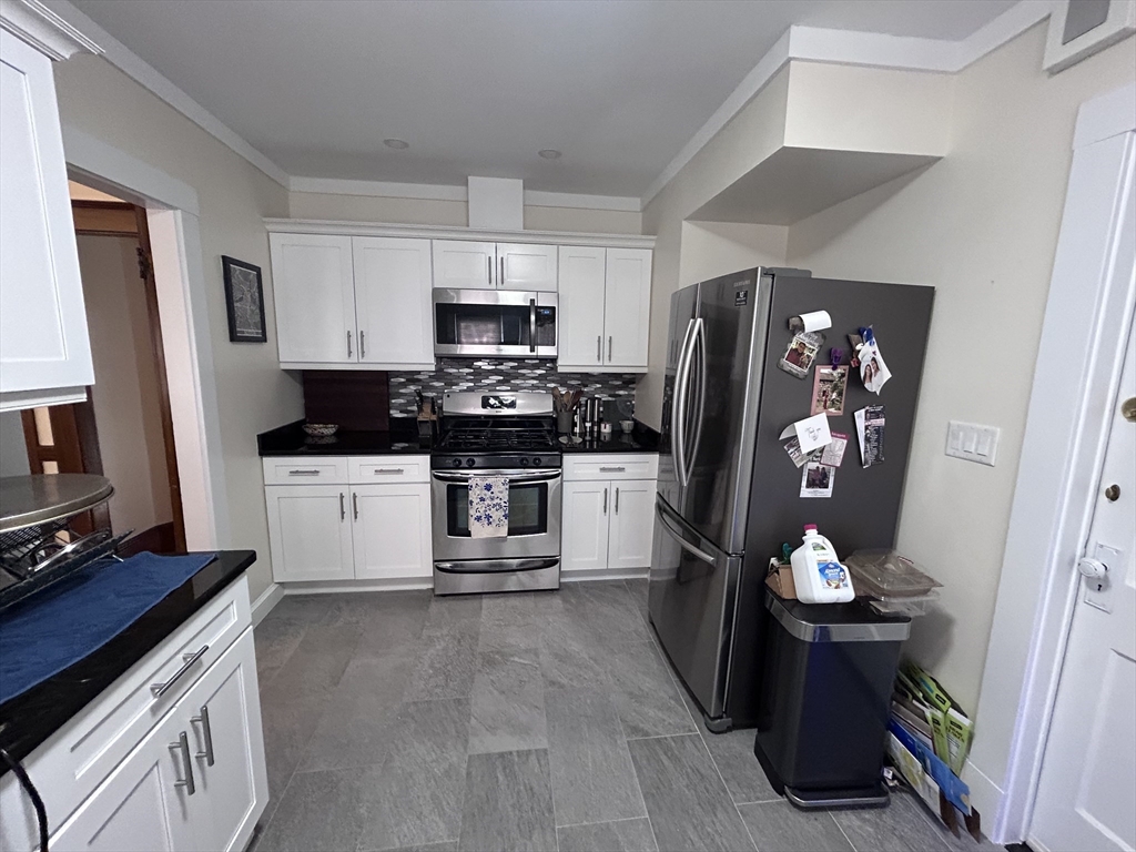 19-21 Virgil Road, Unit 1 Boston, MA 02132 - Photo 2 of 13 a kitchen with stainless steel appliances a refrigerator stove and sink