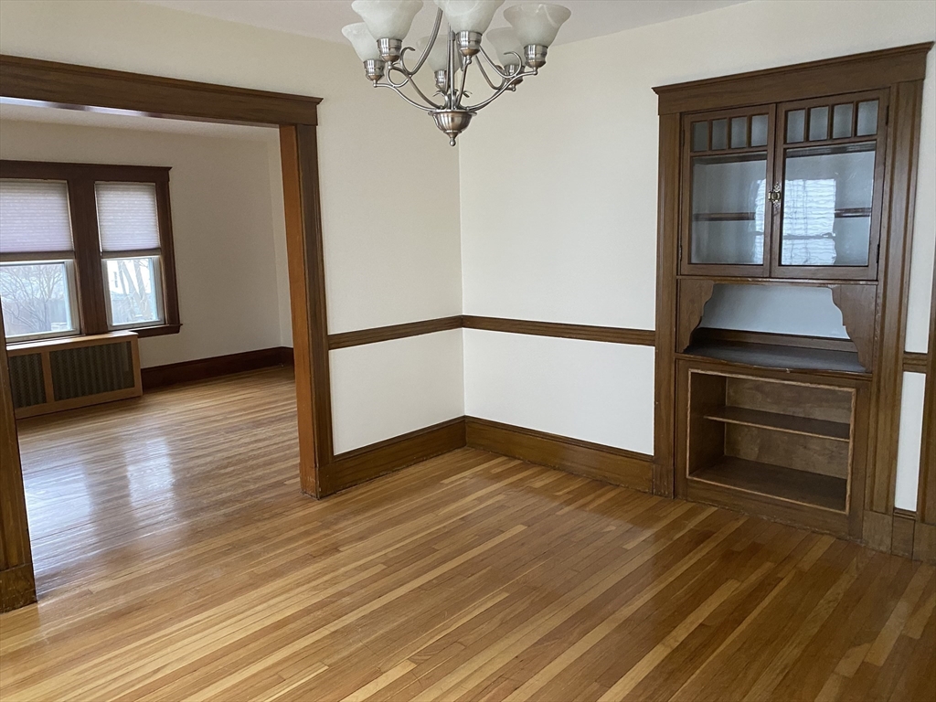 19-21 Virgil Road, Unit 1 Boston, MA 02132 - Photo 5 of 13 a view of empty room with wooden floor and fan