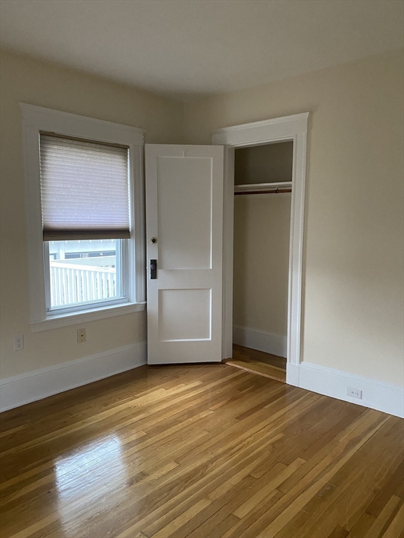 19-21 Virgil Road, Unit 1 Boston, MA 02132 - Photo 7 of 13 a view of an empty room with wooden floor and a window