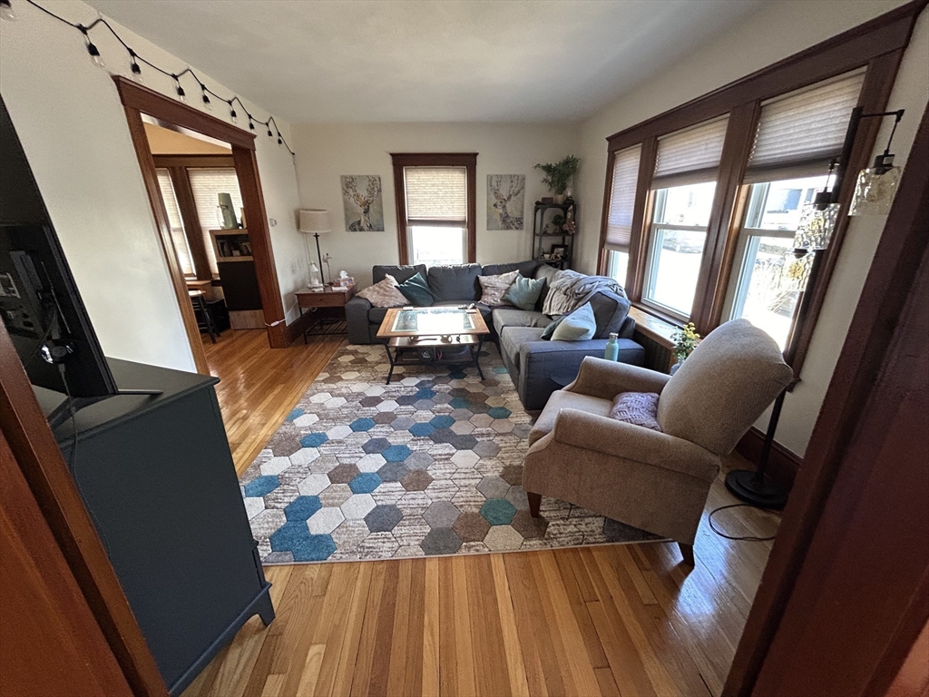 19-21 Virgil Road, Unit 1 Boston, MA 02132 - Photo 9 of 13 a living room with furniture and a fireplace